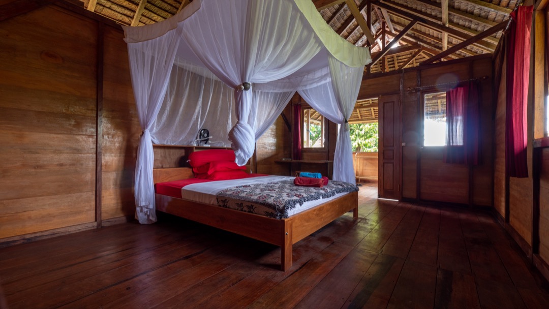 Nakaela Lodge. Blick auf Doppelbett und Terrasse